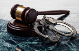 Handcuffs and Gavel on Marble Background