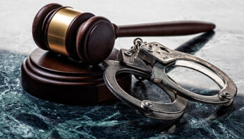 Handcuffs and Gavel on Marble Background